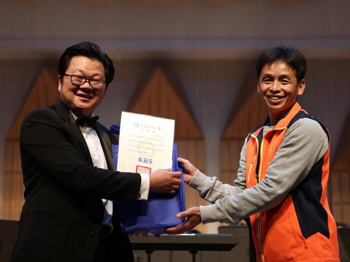學生事務處林國華組長代表學校致贈感謝狀給負責推動「管樂27禮讚」的音樂系呂彥輝老師（左）